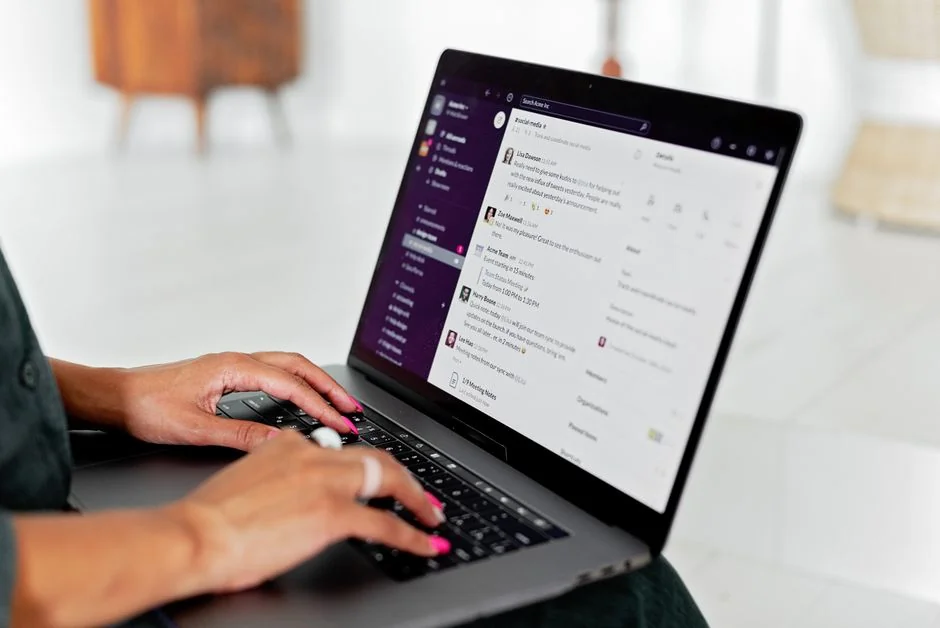 A modern workspace showing hands analyzing marketing data on a laptop and paper documents.
